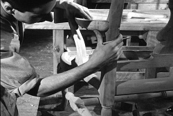 Artisan ébéniste fixant le bras d'une chaise. Image fixe de l'Office national du film (ONF) tirée du film se trouvant en document complémentaire.  © ONF et Encyclopédie du patrimoine culturel de l'Amérique française.