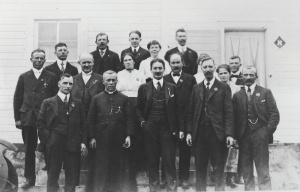 Photograph of a group of Swiss men from Notre Dame de Lourdes standing in front of a building. 