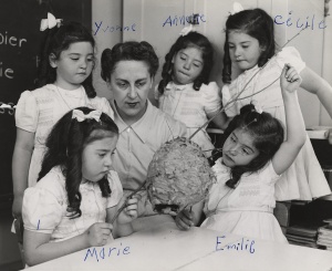 Gaëtane Vézina, entourée des célèbres quintuplées Dionne, qui ont inscrit leur prénom sur la photographie originale, Callander (Ontario), entre 1938 et 1942