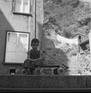 Vue d'un garçonnet assis dans sa charrette en bois au haut d'un escalier, Petit-Champlain, 1950 