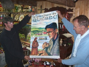 La Province de Québec. Affiche publicitaire montrant Médard Bourgault qui sculpte une statuette devant un paysage où navigue une goélette du Saint-Laurent, vers 1950.