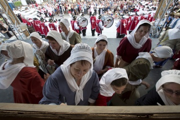 Les bénévoles personnifiant les Filles du roi signent une toile souvenir lors de leur passage à Québec